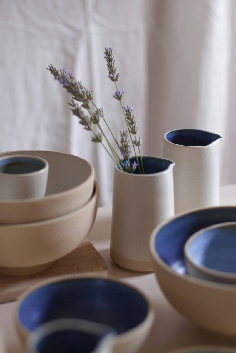 Cream glazed bowls beside a small vase