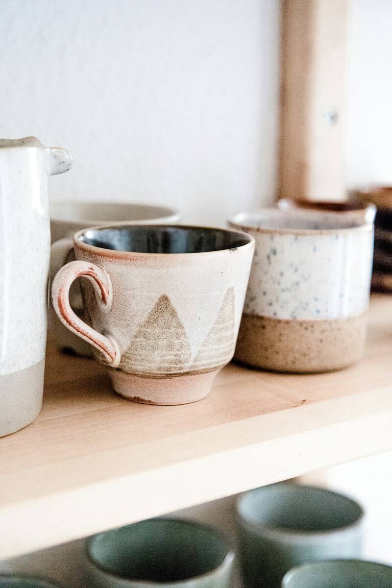 Two handmade stoneware mugs side by side